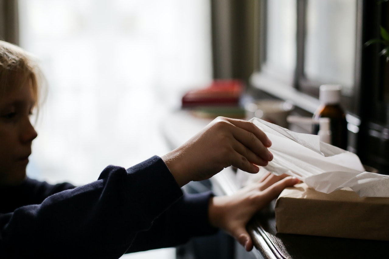 Child grabbing a tissue to represent childhood illnesses