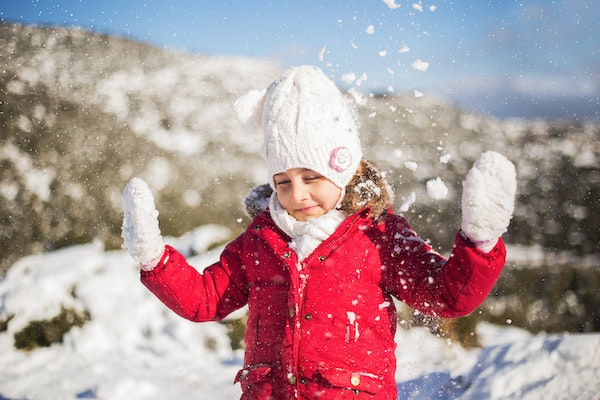 Child in coat, hat and gloves to represent keeping your children warm